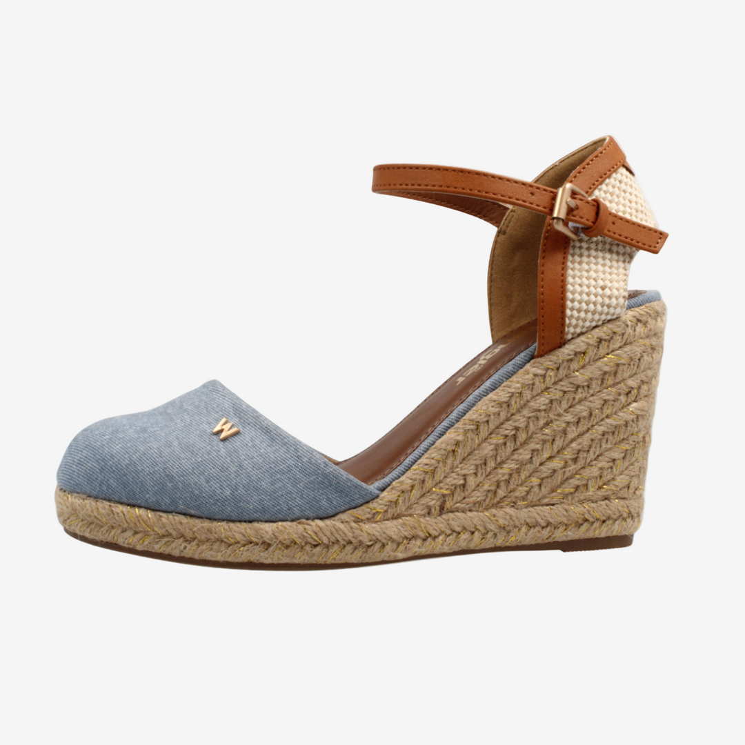 Wedge sandal with blue upper and brown wedge sole on a white background