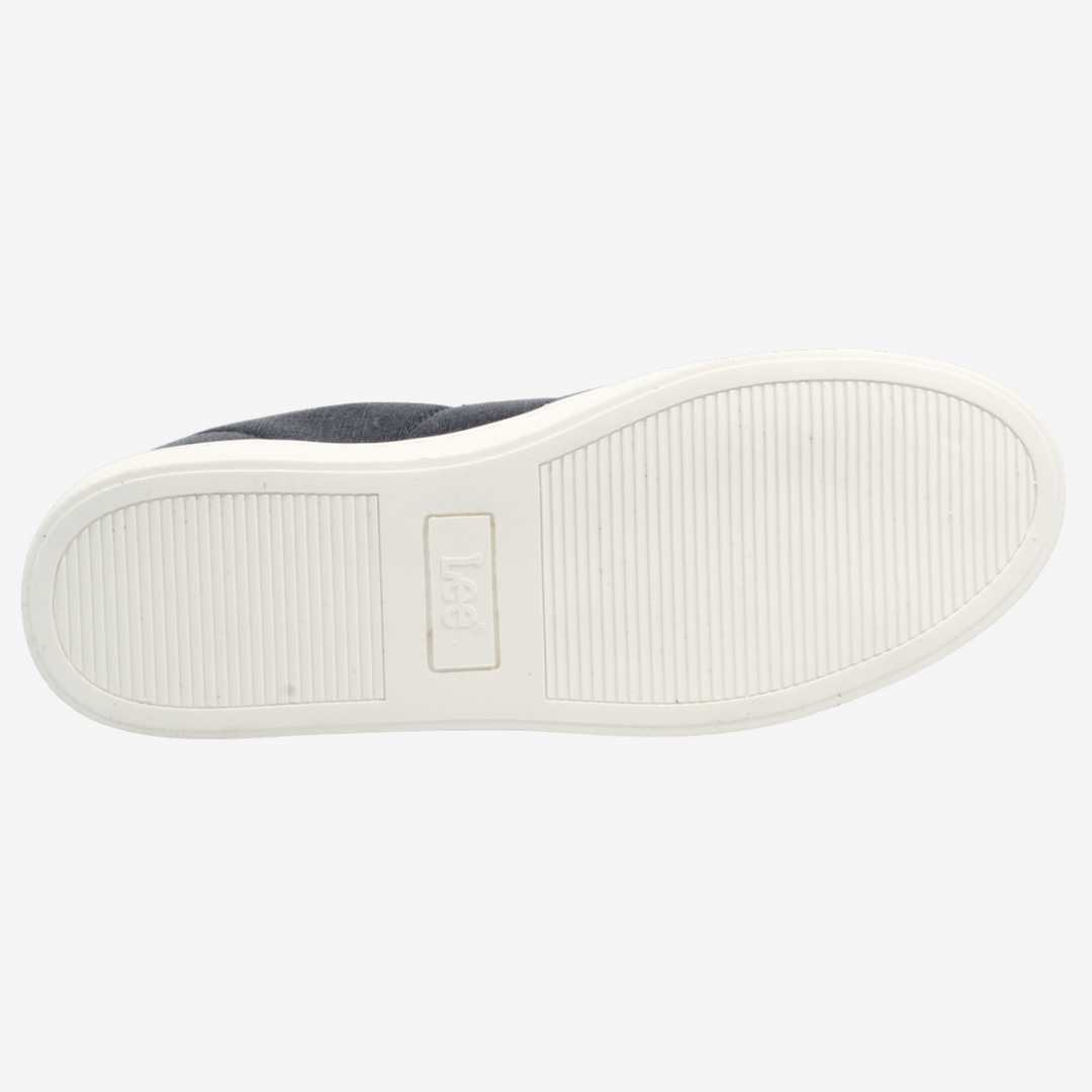 Close-up of a shoe sole with a white sole and gray fabric upper on a light gray background