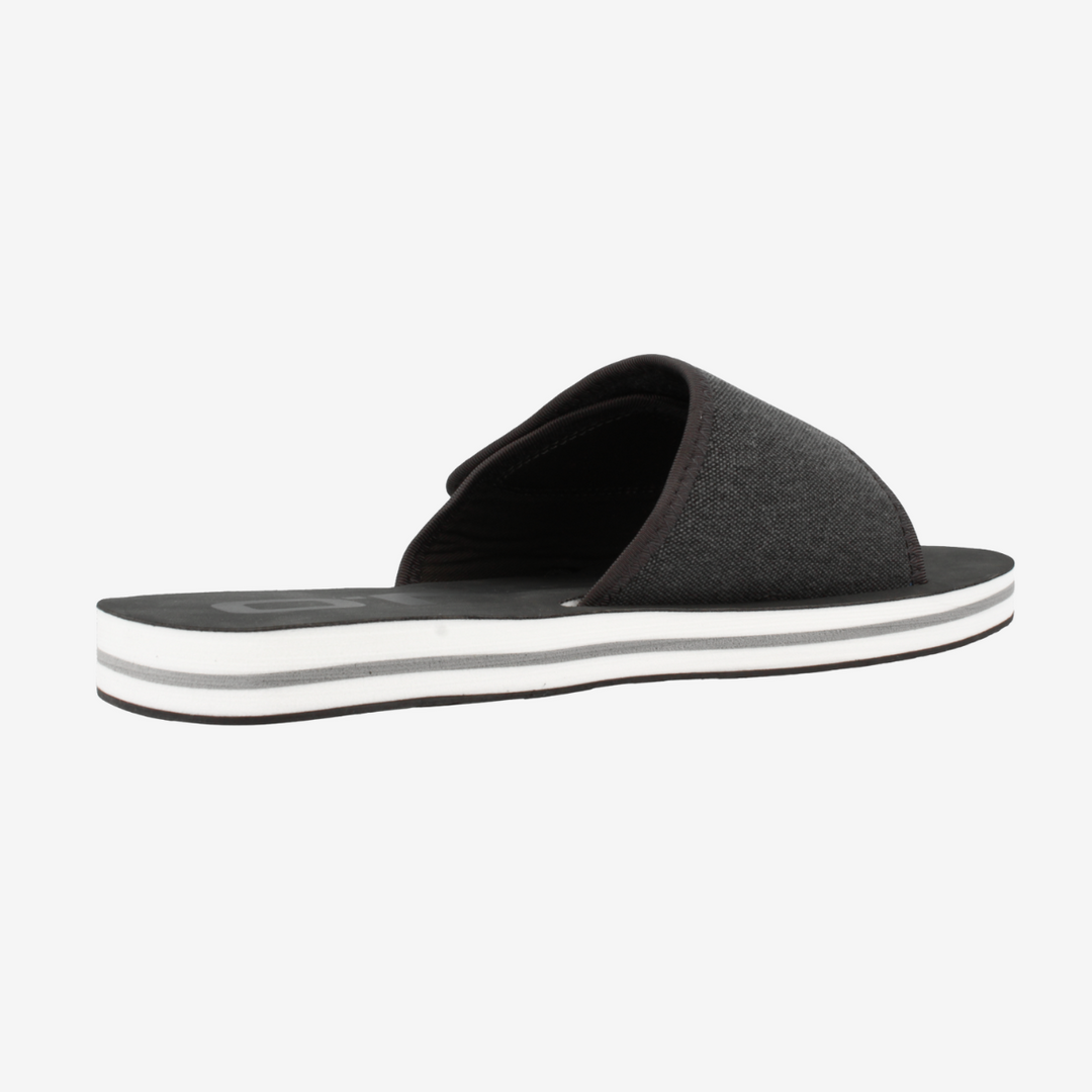 Black slide sandal with a white sole on a light gray background