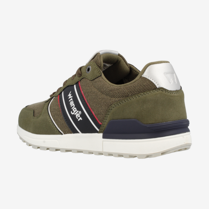 Green sneaker with white sole on a light gray background
