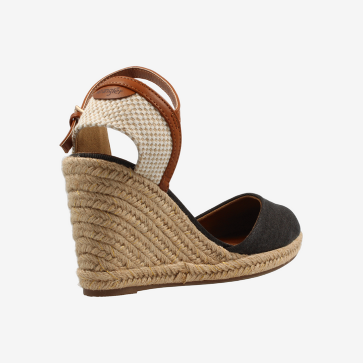 Woven wedge sandal with a black footbed on a white background