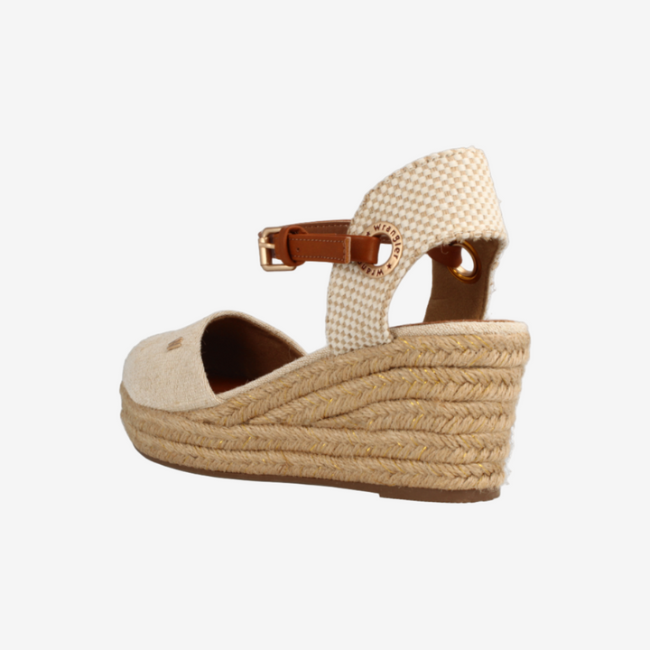 Beige wedge sandal with espadrille sole on a light gray background