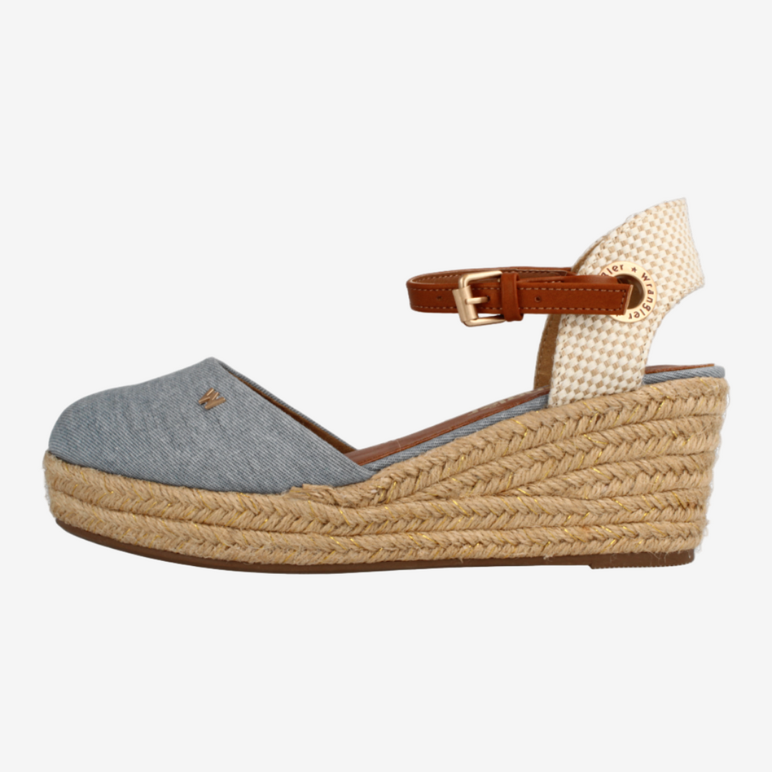 Wedge sandal with textured sole and brown strap on a white background