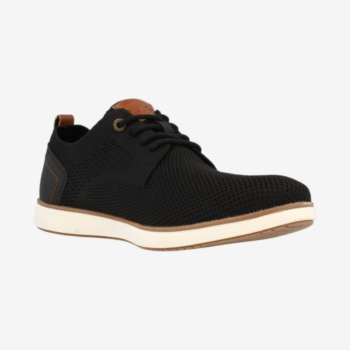 Black sneaker with white sole on a light gray background
