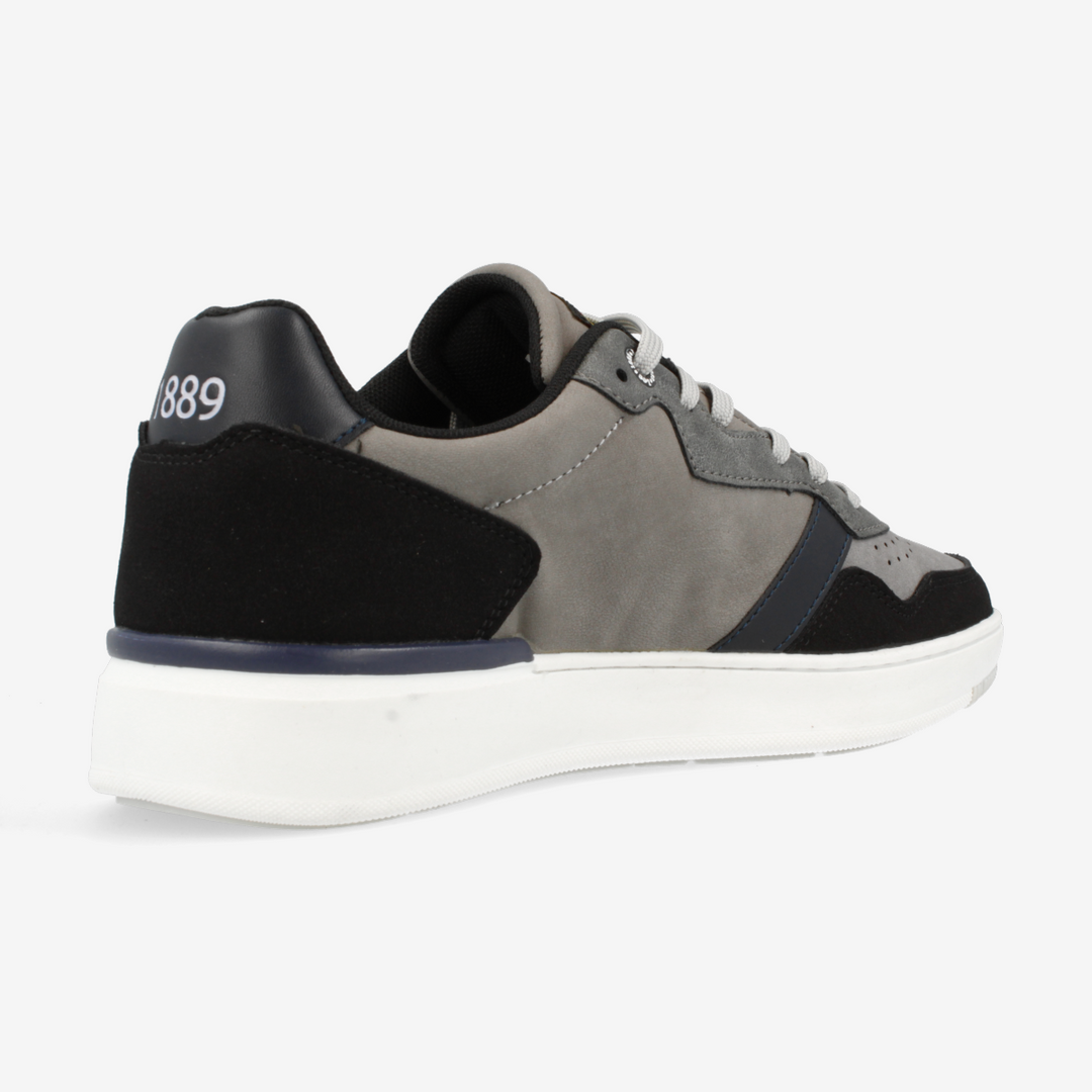 Gray and black sneaker with a white sole on a light gray background