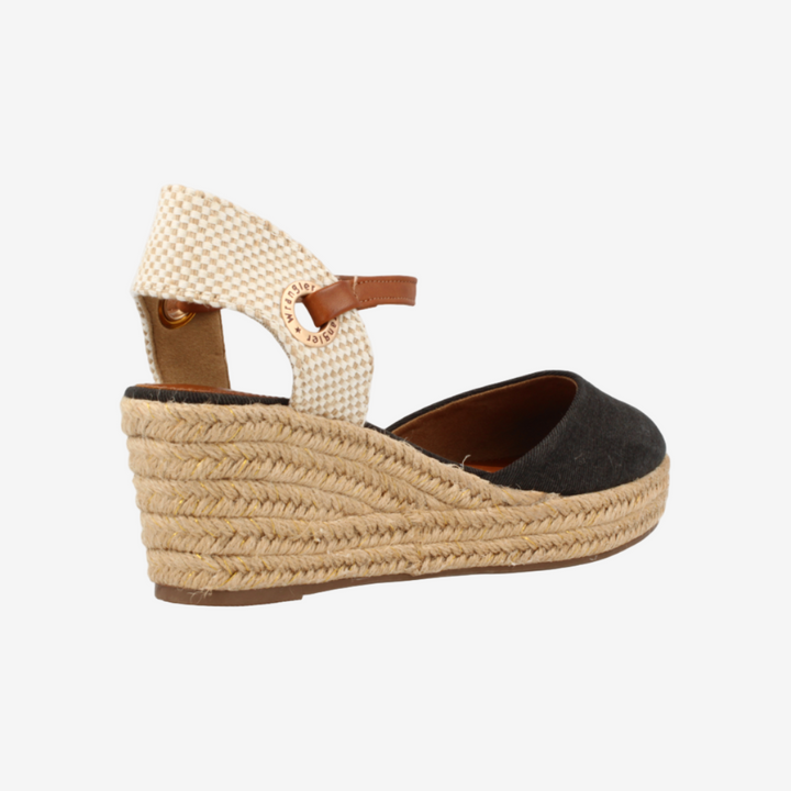 Woven wedge sandal with a black sole on a white background
