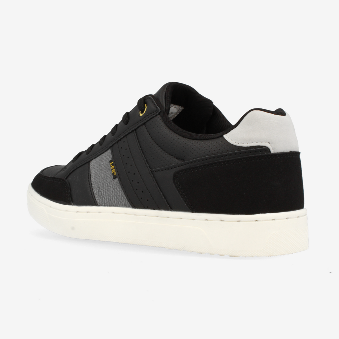 Black sneaker with white sole on a light gray background
